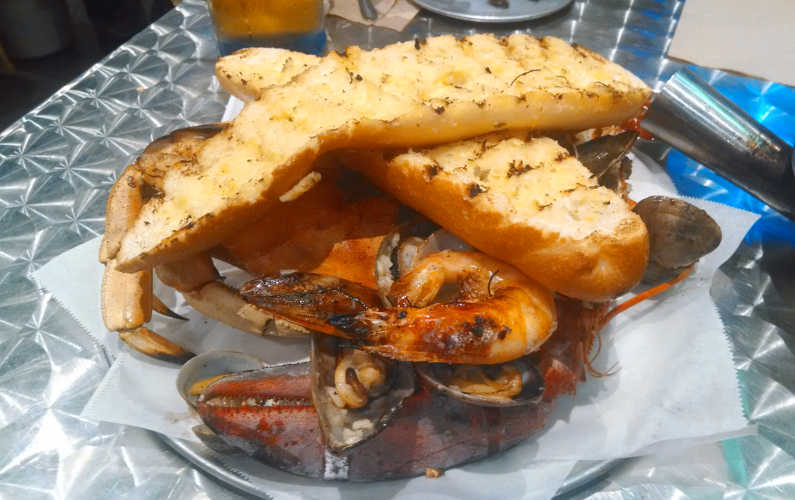 Grilled Bread Over a Pile of Grilled Shrimp and Seafood From Big T's Seafood Market Bar 