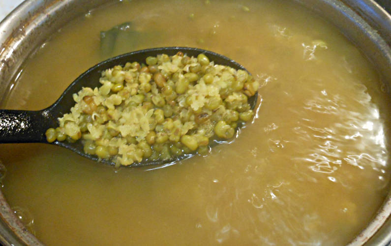 Close Up of Spoon of Boiled Mung Bean Over Pot of Cooking Mung Bean Recipe