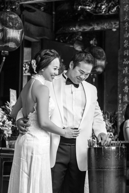 Nadia in a White Dress and JM in a Black and White Tuxedo Selecting Sticks at Lungshan Temple By Ching Hua Bridal Art