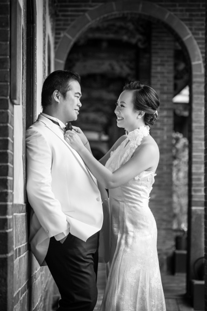Nadia in a White Dress Fixing JM's Tie in a Black and White Tuxedo at Lungshan Temple By Ching Hua Bridal Art